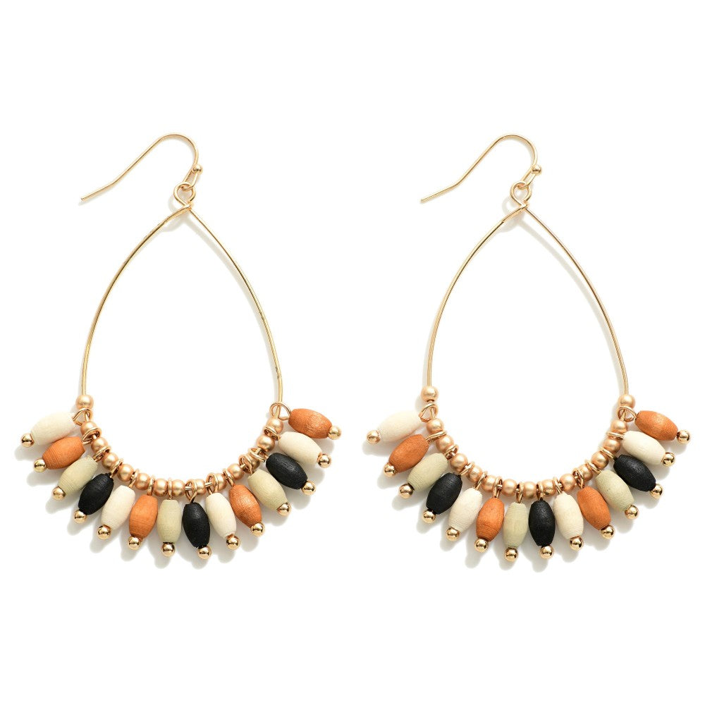 Teardrop earrings with multicolored ellipsoid wood beads separated by gold circular beads (camel, black, ivory) Approximately 1.5” wide Tassel beads approximately 0.5” long