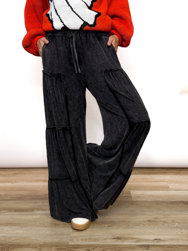 Black acid washed tiered flared wide leg boho pants with elastic drawstring waist and side pockets. Soft cotton, perfect for dressing up or down.