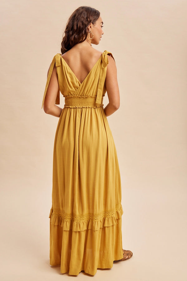 Women’s mustard yellow boho summer dress with ruffle and lace accents, pockets and ruffle details with self tying straps and smocked stretchy waist.