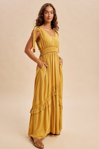 Women’s mustard yellow boho summer dress with ruffle and lace accents, pockets and ruffle details with self tying straps and smocked stretchy waist.