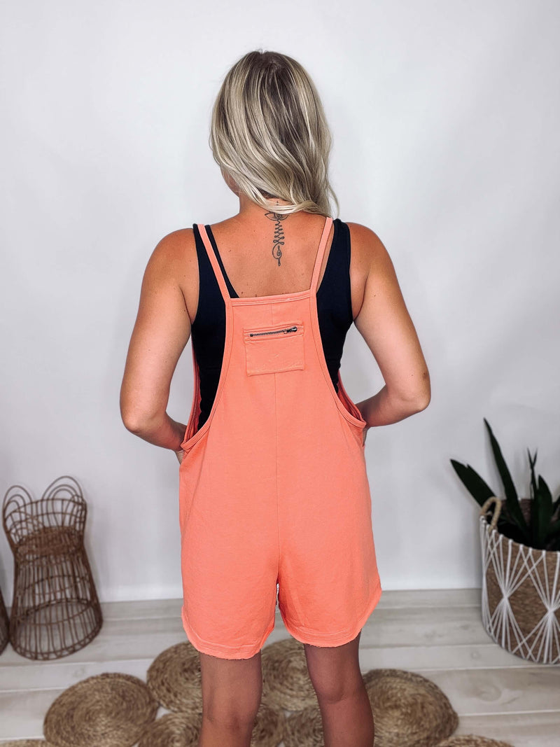 Ces Femme coral V-neck spaghetti strap romper with two pockets. Oversized and relaxed fit. Made from 85% cotton and 15% polyester.