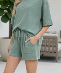 Close-up of the textured raised rib fabric and drawstring waistband on the Jade green shorts.