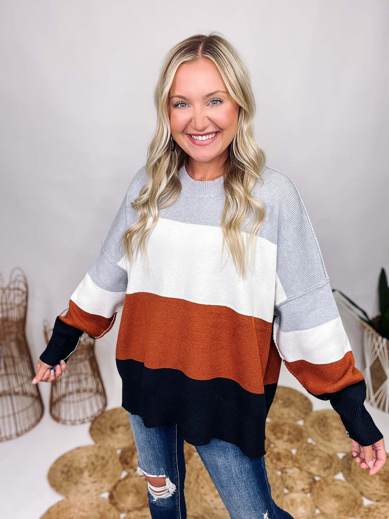 Neutral Grey, White, Rusty Brown, Black Colorblock Stripe Knit Sweater Oversized Fit Side Slits Ribbed Cuffs and Bottom Band Round Hem Neckline Soft and Stretchy Oversized Fit 50% Acrylic, 230% Nylon, 20% Polyester