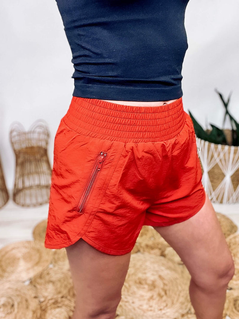Rusty Copper Smocked Waistband Running Shorts Zipper Side Pocket Split Hem Built-in Briefs Relaxed Fit Approx. Inseam: 2 1/4" Shell: 100% Nylon, Lining: 92% Polyester, 8% Spandex