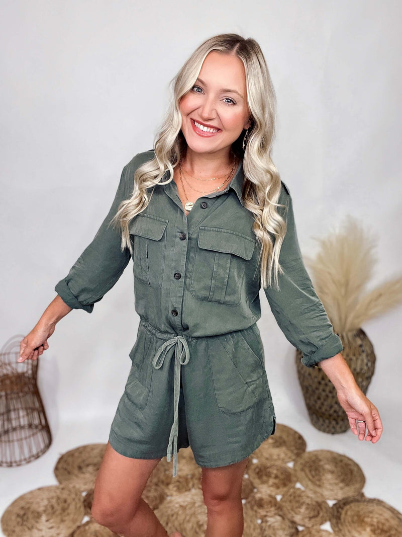 She and Sky Fall Utility Romper Washed Olive Long Sleeve Romper Button Up Front Button Roll Up Cuffs Functioning Waist Drawstring Button Shoulder Details Side Dips Soft Flowy Material Relaxed Fit 100% Rayon