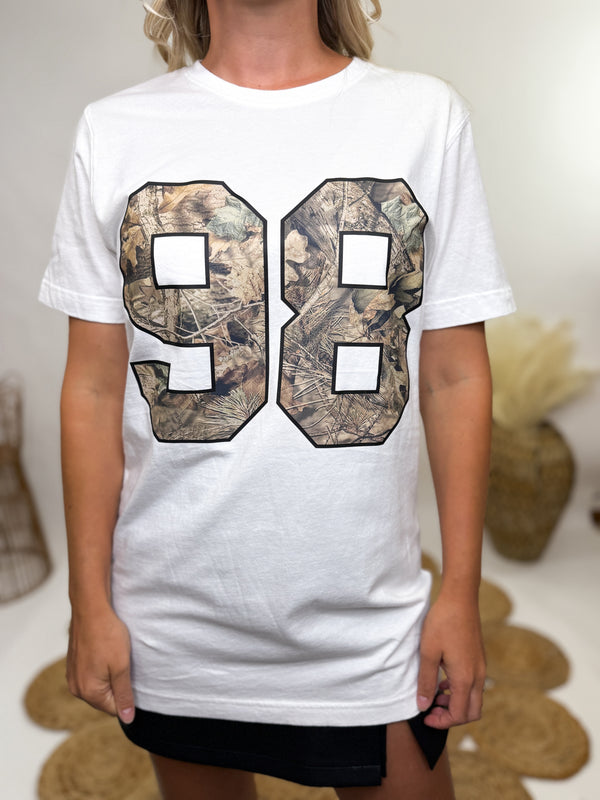 Close-up of screen-printed "98" camouflage graphic on white tee.