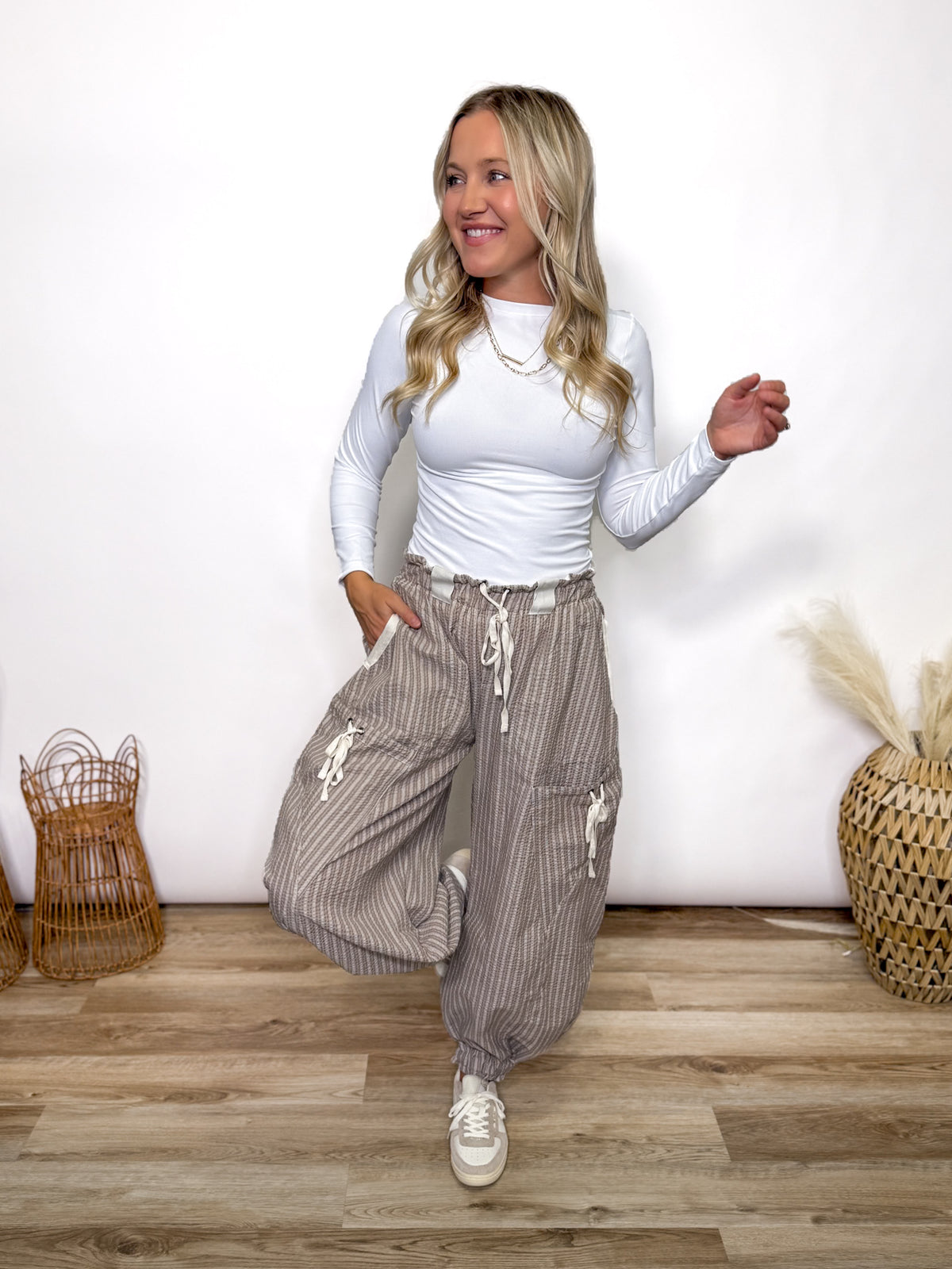 Stay comfy and stylish in these coco and white striped jogger pants. Relaxed fit, elastic drawstring waist, pockets, and cuffs. Perfect neutral joggers for fall outfits.