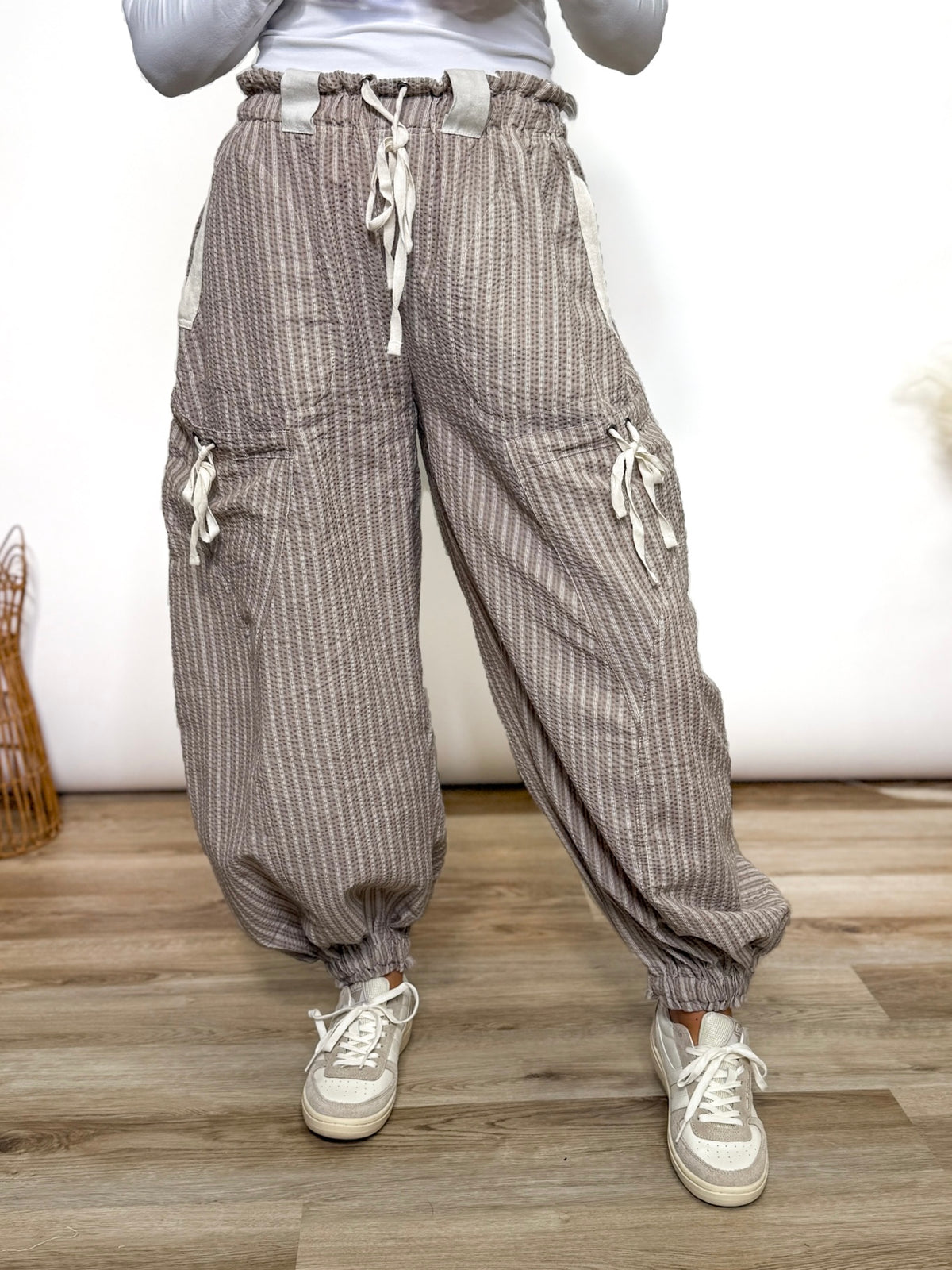Stay comfy and stylish in these coco and white striped jogger pants. Relaxed fit, elastic drawstring waist, pockets, and cuffs. Perfect neutral joggers for fall outfits.