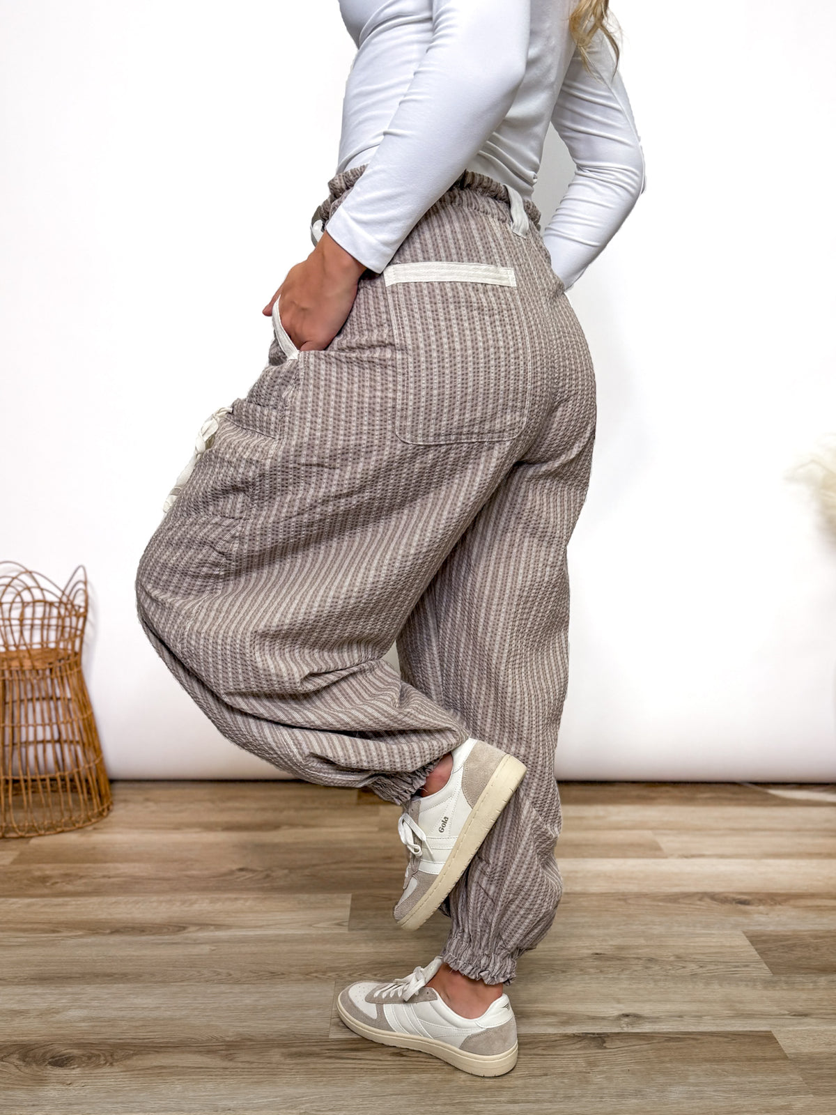 Stay comfy and stylish in these coco and white striped jogger pants. Relaxed fit, elastic drawstring waist, pockets, and cuffs. Perfect neutral joggers for fall outfits.