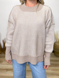 Cozy meets trendy in this neutral two tone ribbed sweater. Featuring exposed seams, side slits, and a relaxed fit. Perfect oversized fall to winter sweater.