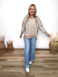 Cozy meets trendy in this neutral two tone ribbed sweater. Featuring exposed seams, side slits, and a relaxed fit. Perfect oversized fall to winter sweater.