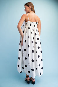 Woman wearing a polka dot smocked maxi dress with adjustable straps styled for summer