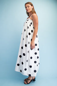 Woman wearing a polka dot smocked maxi dress with adjustable straps styled for summer