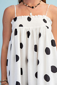 Woman wearing a polka dot smocked maxi dress with adjustable straps styled for summer