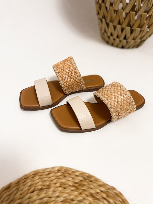 Close-up of Soda Raffia & Ivory Woven Double Strap Slide Sandals featuring textured woven raffia straps, an ivory band, and a trendy square toe design. Women's spring and summer sandals. 