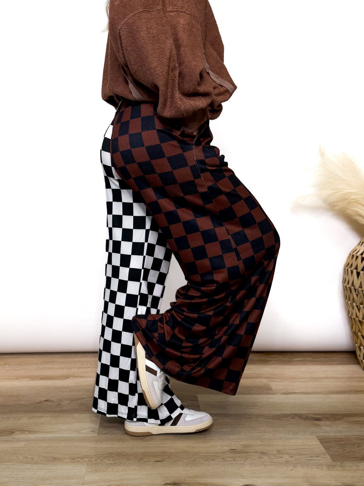 Split Decisions Checker Print Wide Leg Pants half brown/black, half black/white. Stretchy ribbed wide leg pants with elastic waistband and side pockets styled with oversized pullover and sneakers
