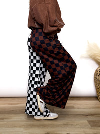 Split Decisions Checker Print Wide Leg Pants half brown/black, half black/white. Stretchy ribbed wide leg pants with elastic waistband and side pockets styled with oversized pullover and sneakers