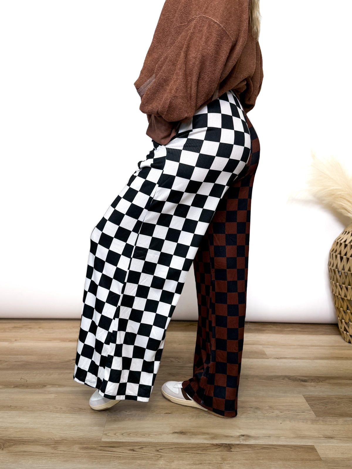 Split Decisions Checker Print Wide Leg Pants half brown/black, half black/white. Stretchy ribbed wide leg pants with elastic waistband and side pockets styled with oversized pullover and sneakers