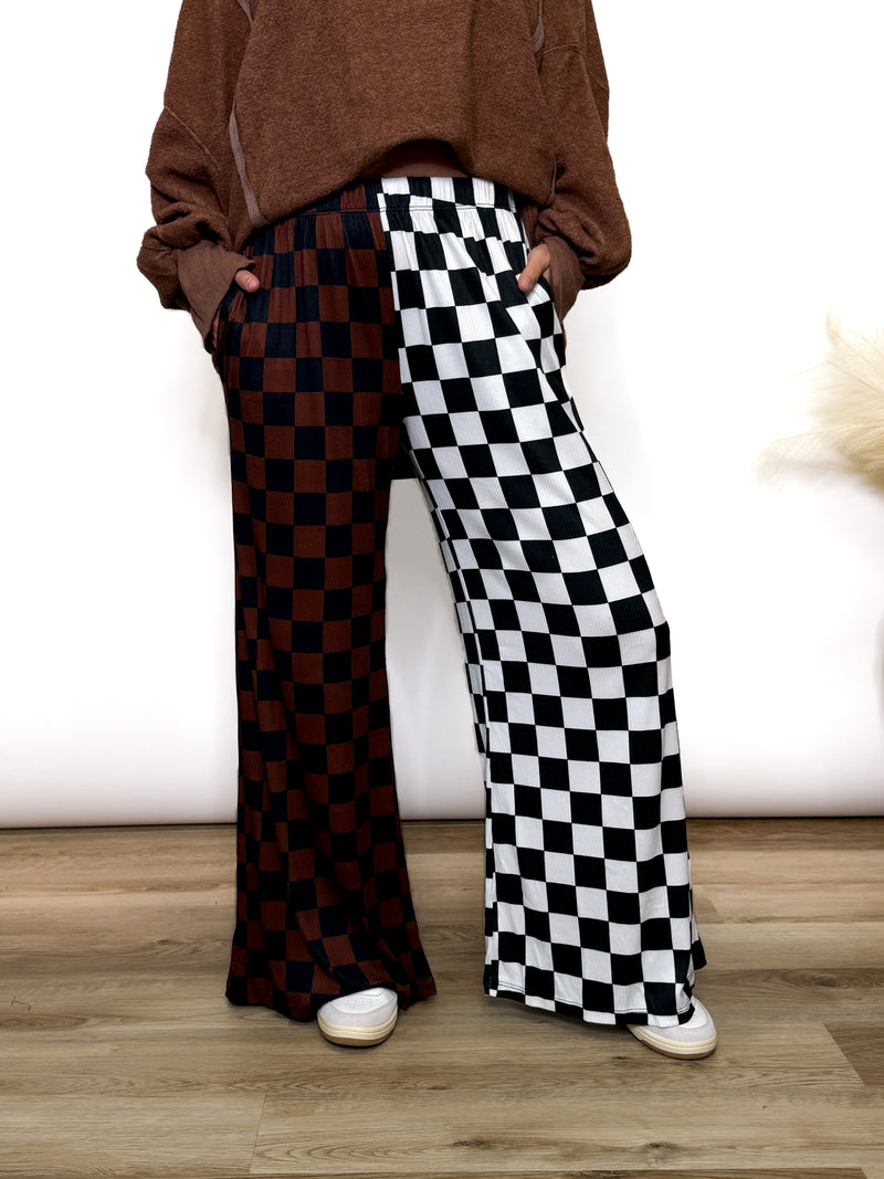 Split Decisions Checker Print Wide Leg Pants half brown/black, half black/white. Stretchy ribbed wide leg pants with elastic waistband and side pockets styled with oversized pullover and sneakers