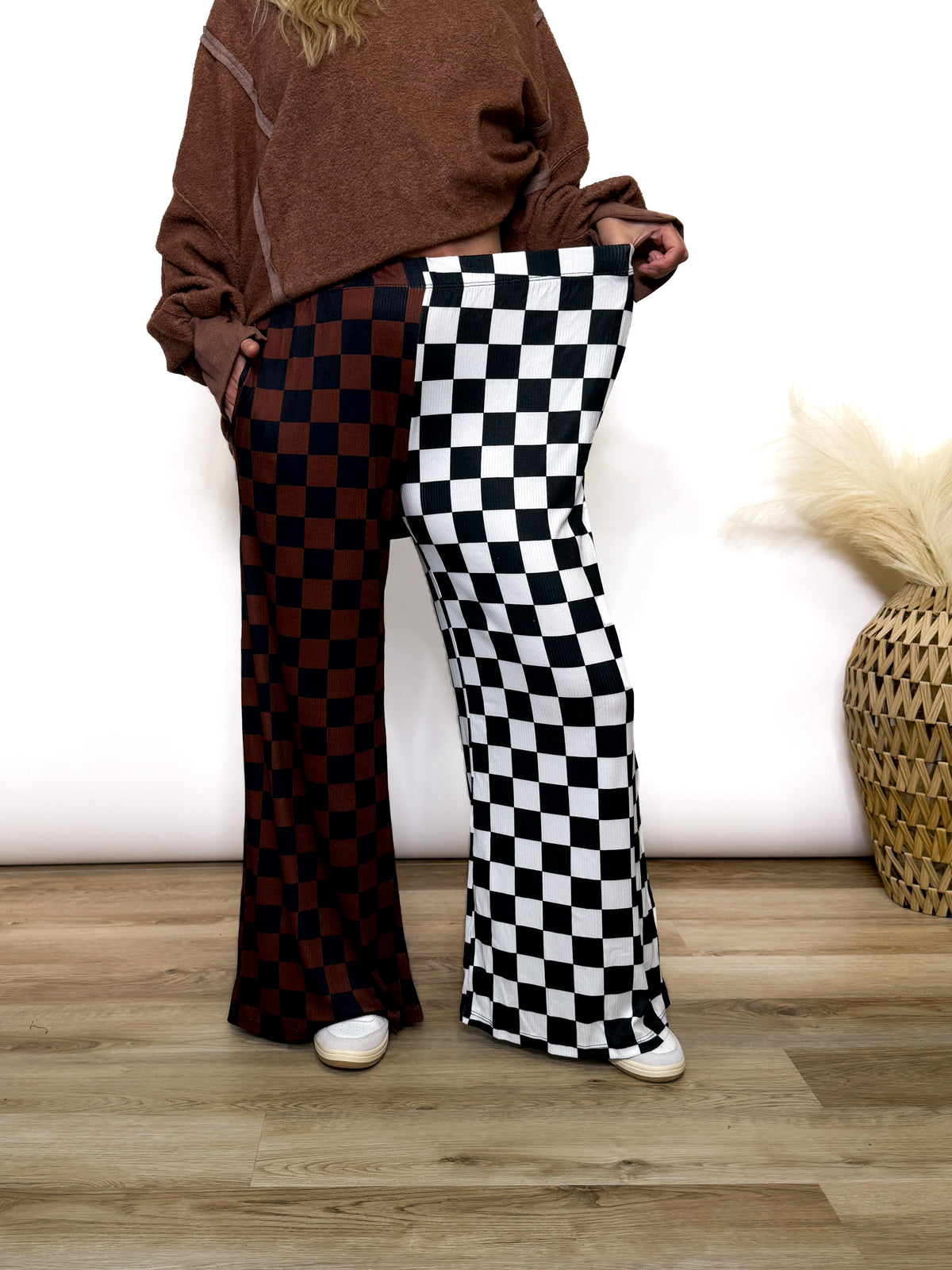 Split Decisions Checker Print Wide Leg Pants half brown/black, half black/white. Stretchy ribbed wide leg pants with elastic waistband and side pockets styled with oversized pullover and sneakers
