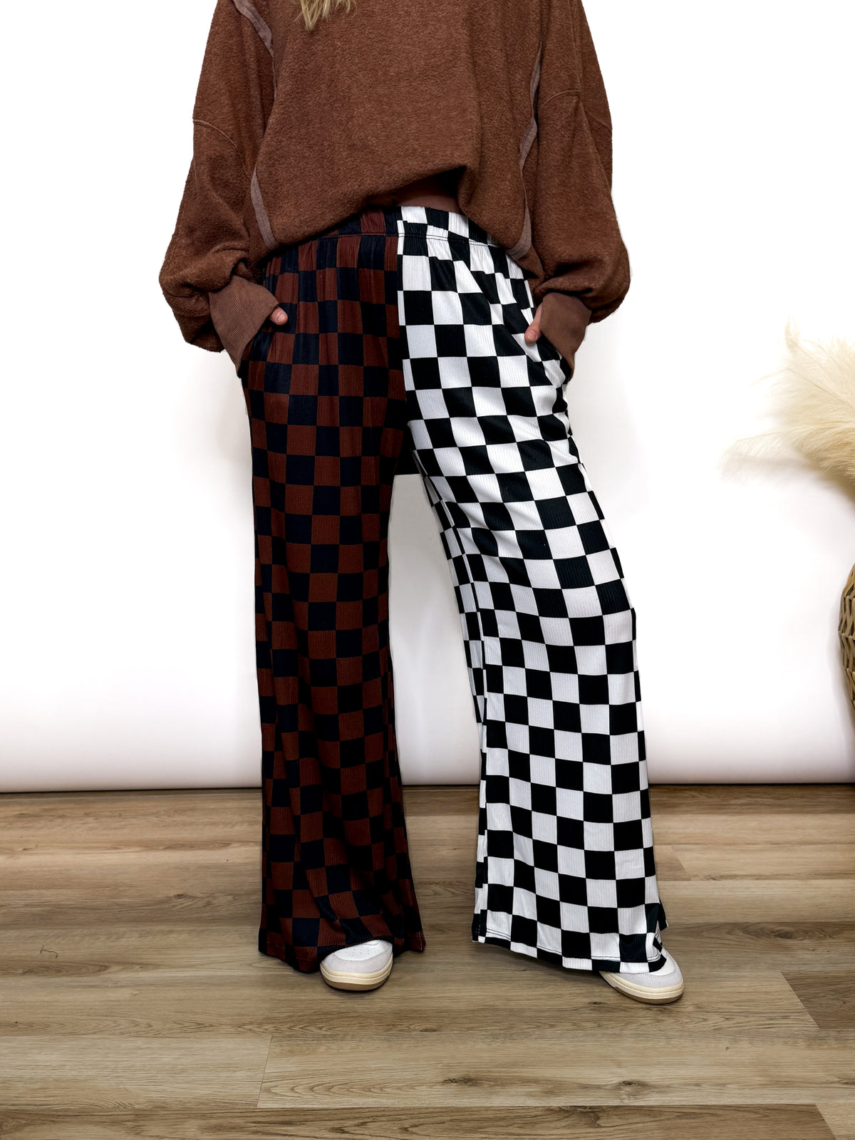 Split Decisions Checker Print Wide Leg Pants half brown/black, half black/white. Stretchy ribbed wide leg pants with elastic waistband and side pockets styled with oversized pullover and sneakers