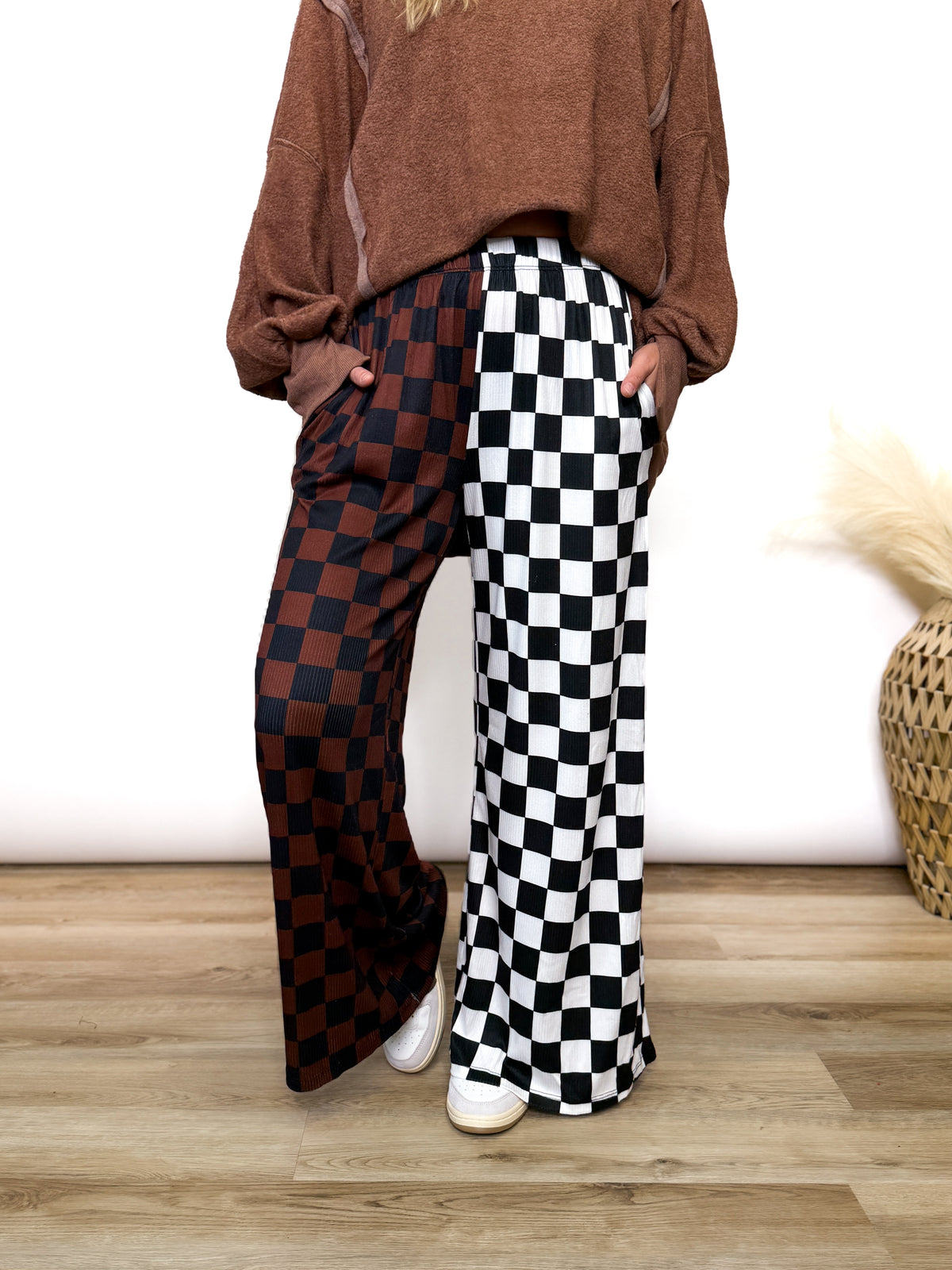 Split Decisions Checker Print Wide Leg Pants half brown/black, half black/white. Stretchy ribbed wide leg pants with elastic waistband and side pockets styled with oversized pullover and sneakers