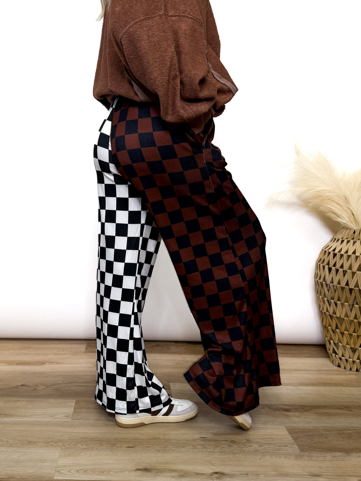 Split Decisions Checker Print Wide Leg Pants half brown/black, half black/white. Stretchy ribbed wide leg pants with elastic waistband and side pockets styled with oversized pullover and sneakers