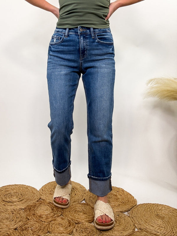 Vervet by Flying Monkey High-Rise Cuffed Cropped Straight Leg Jeans in a dark wash. Features a 10” rise, 27” cropped length, and a stylish 4” cuff with comfort stretch for a flattering fit.