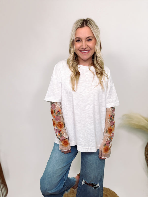 Women’s white t-shirt with floral mesh lace layered underneath.