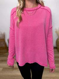 fuchsia ribbed long sleeve top with exposed seams and relaxed fit